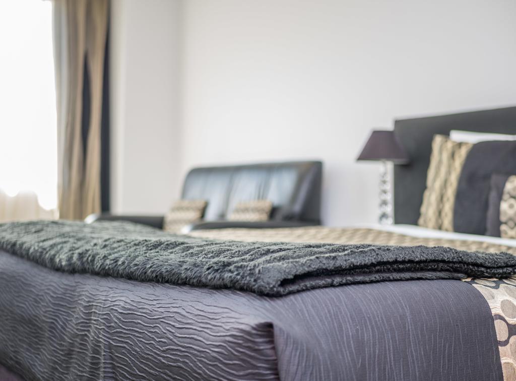 Bellano Motel Suites Christchurch Kültér fotó A bed with a throw