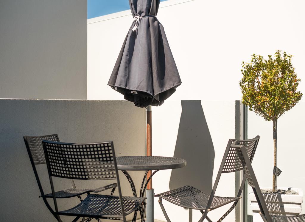 Bellano Motel Suites Christchurch Kültér fotó A patio set