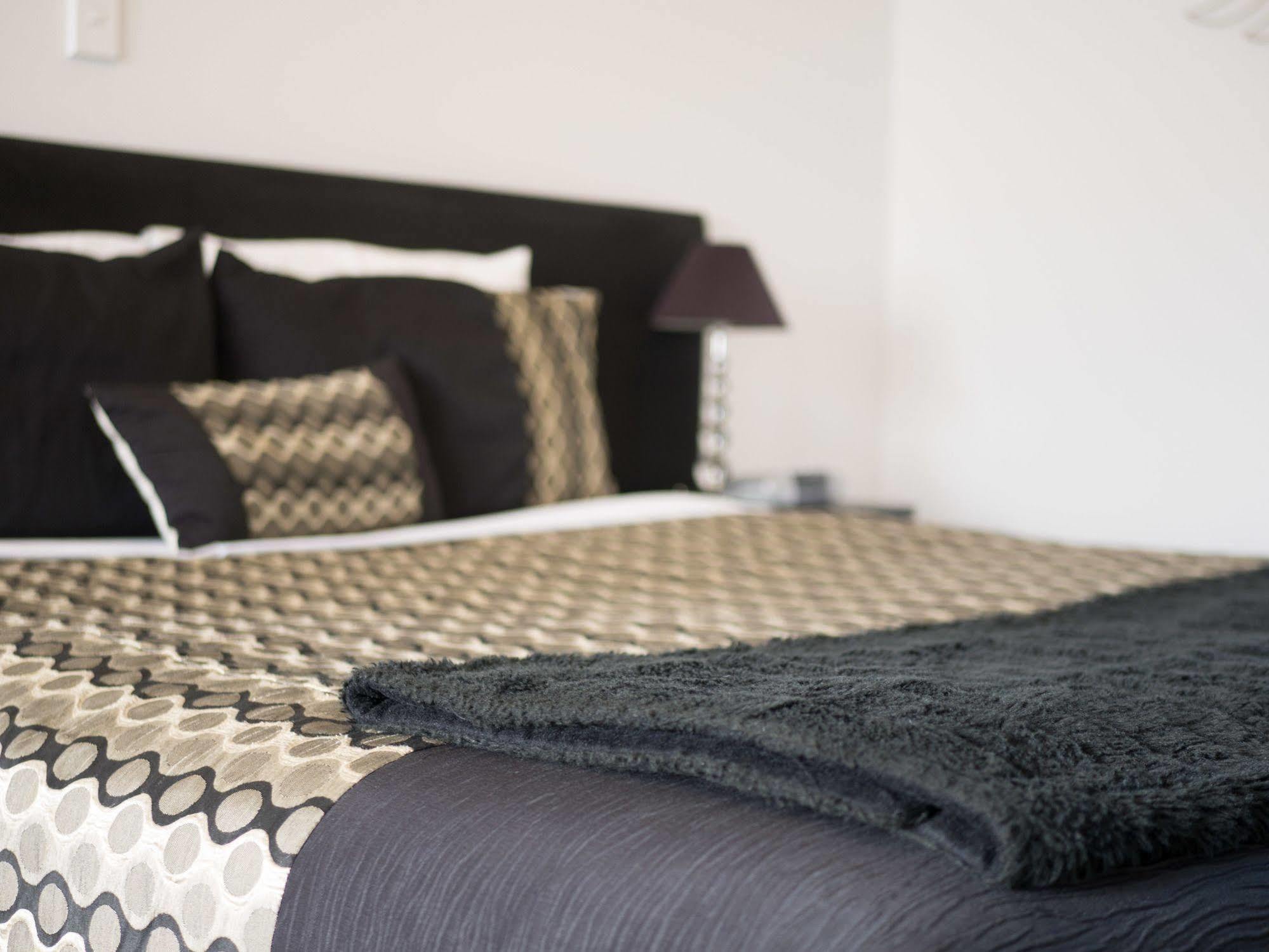 Bellano Motel Suites Christchurch Kültér fotó A bed with a throw